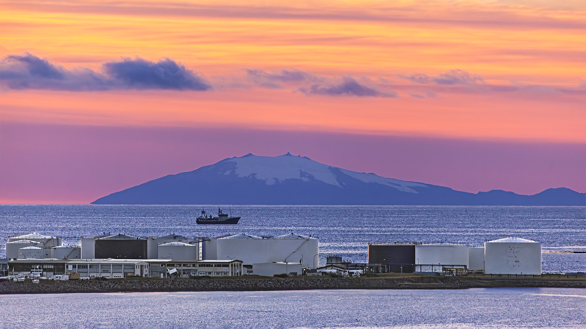Fossile Energie versus Erdwärme. Mineralöllager vor dem Hintergrund von „Snæfellsnes“, der schneebedeckten Vulkanhalbinsel in Sichtweite.